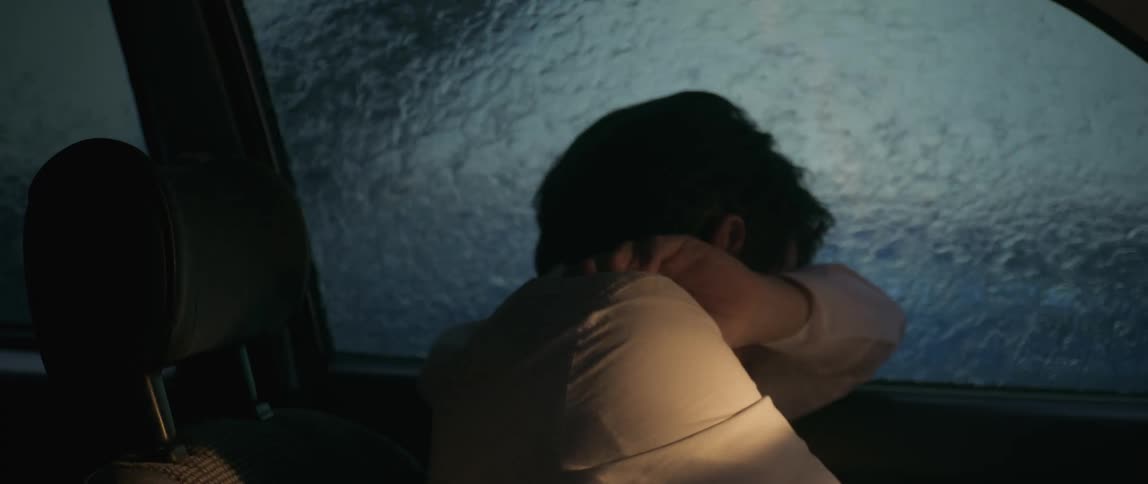 Man inside a car vehicle on a rainy day and a bright light suddenly appearing