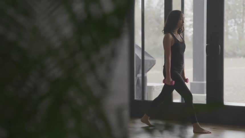 A woman is crouching as she exercises
