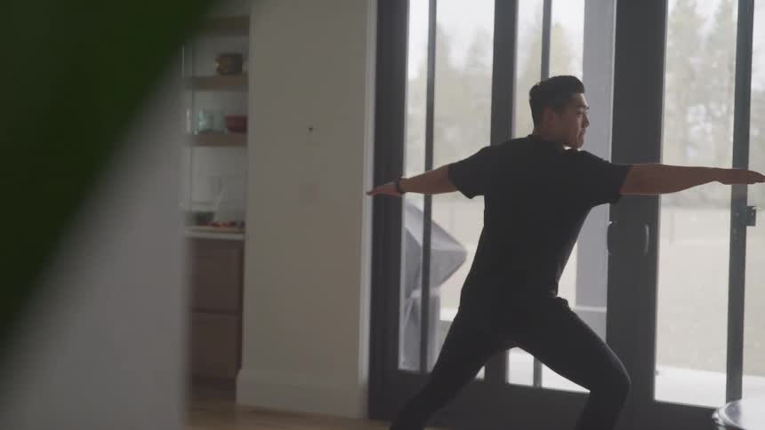 Man standing in front of door stretching arms and legs in yoga position