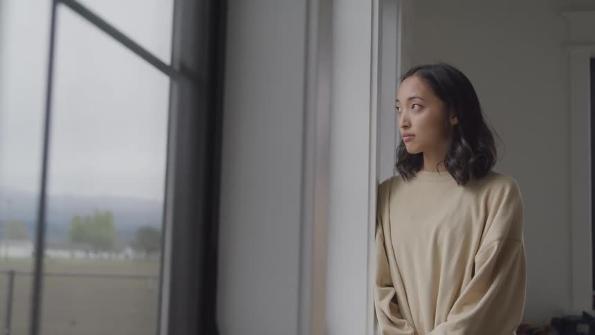Woman inside the house looking out the window