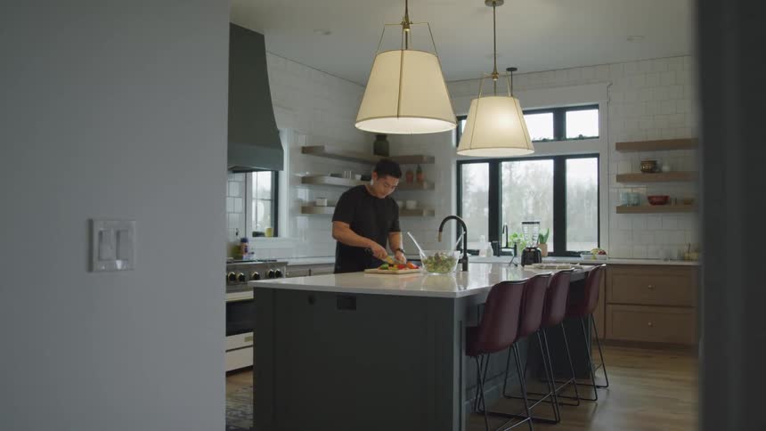 A man is making a salad in the kitchen