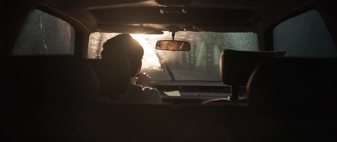 People driving a vehicle on a rainy day when suddenly a bright light appears