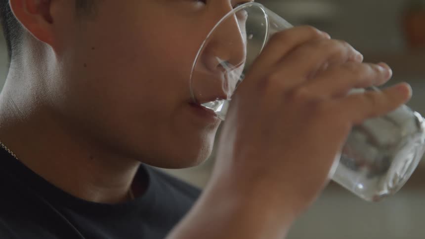 A man drinks a glass of water