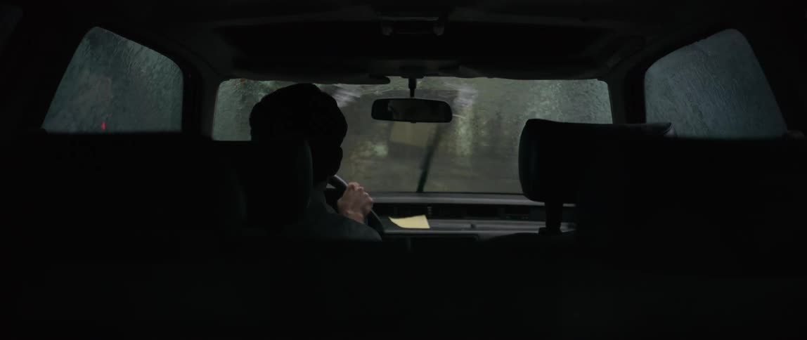 Person driving a vehicle and crossing a bridge on a rainy day