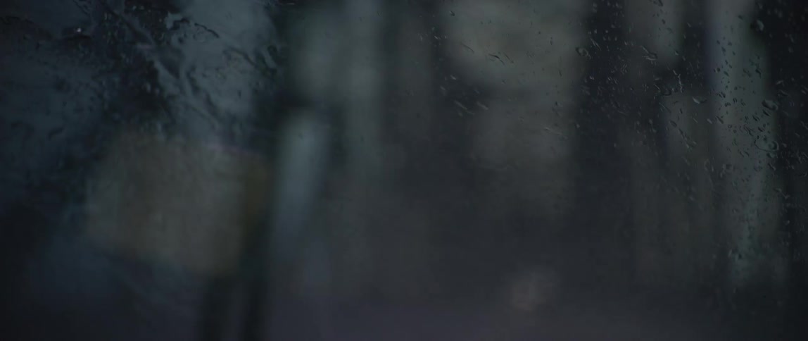 A man wipes his window as he drives during a heavy rain storm