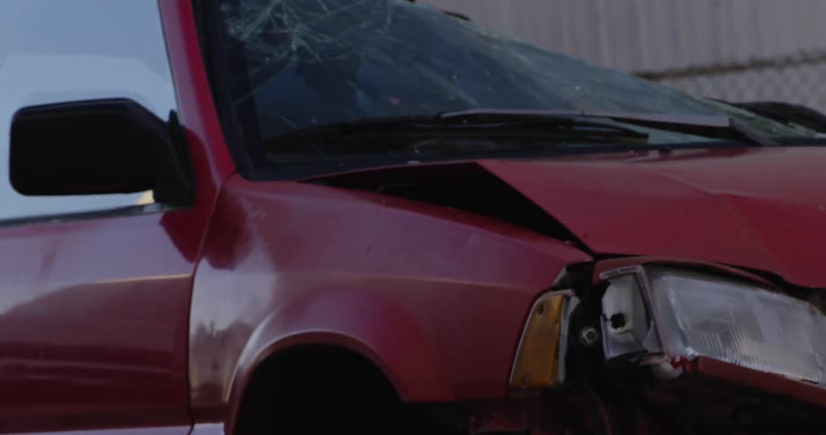 A wrecked car being towed in a junk yard