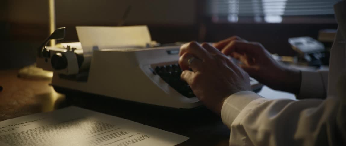A set of hands type on a typewriter