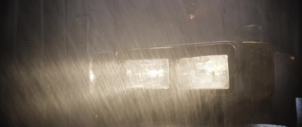 Close up of a trucks headlights at night in the rain