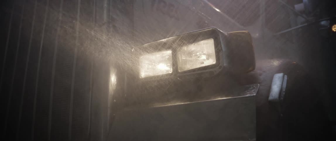 Truck with headlights on in heavy rain