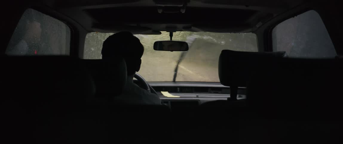 A man driving a car through heavy rain that quickly passes