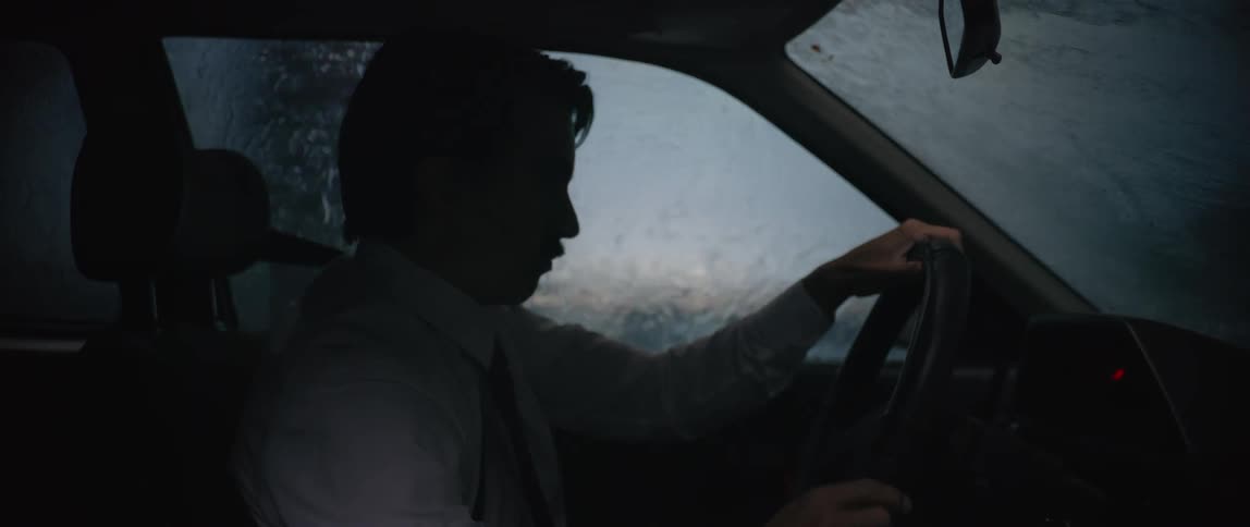 A man looks nervous as he drives in heavy rain