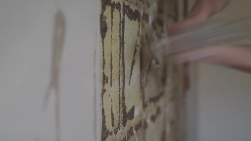 A man hits the wall with a hammer
