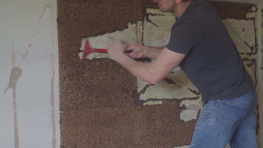 A woman using a tool to sand a wall