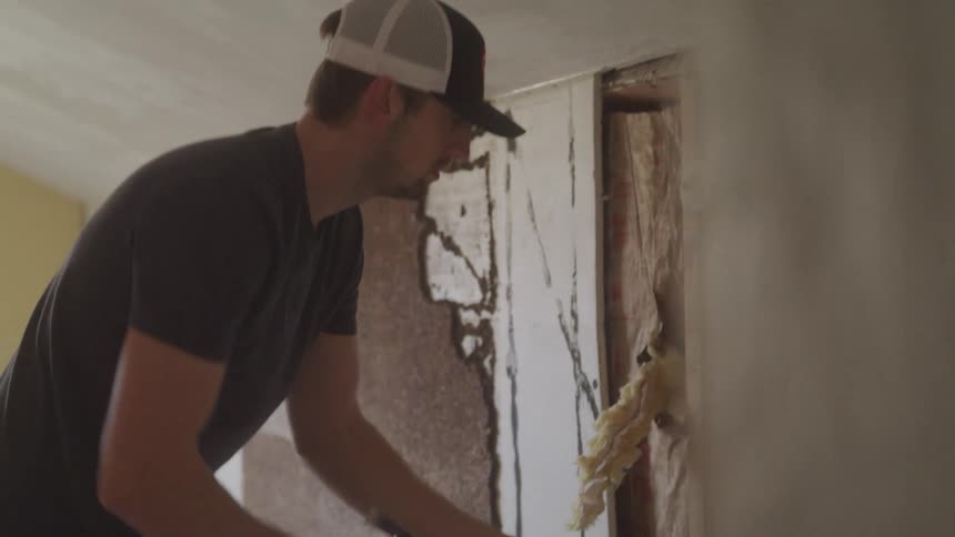 A man breaks apart a wall