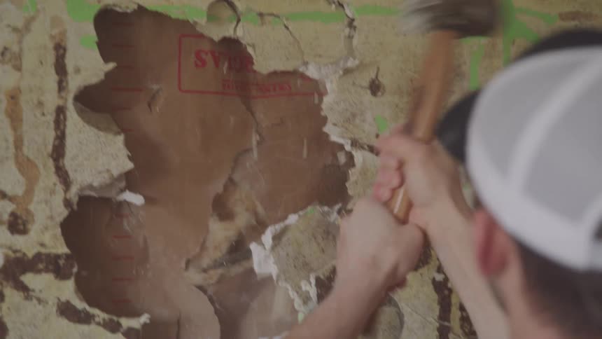 Man with a hammer breaking the wall