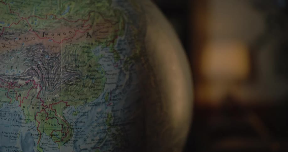 Close up of a detailed terrestrial globe in a dimly lit room