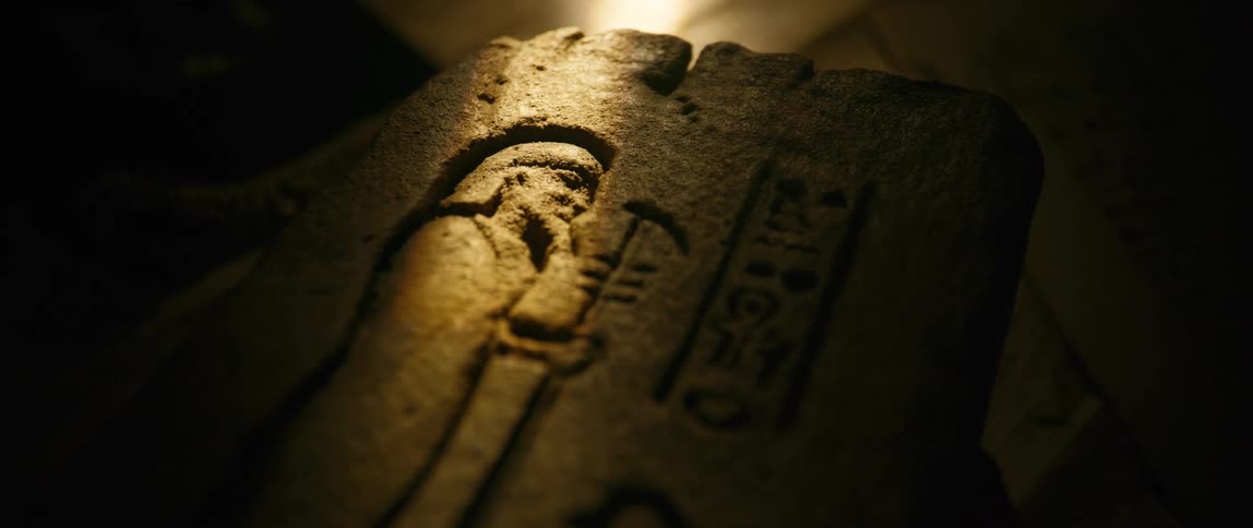 A carving of a figure is in the piece of stone