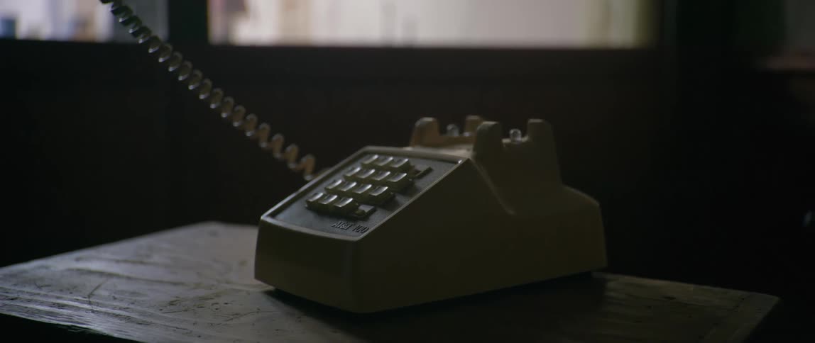 Telephone with handset on top of a wooden bench