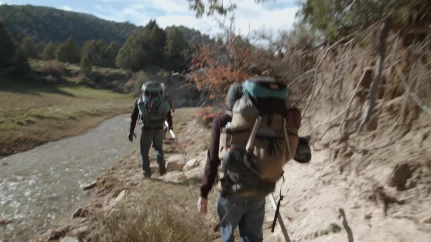 People are hiking along a small stream