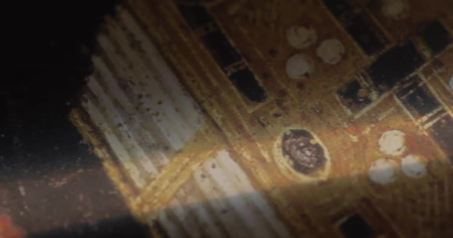 A persons fingers hover near a book with a cross on the cover