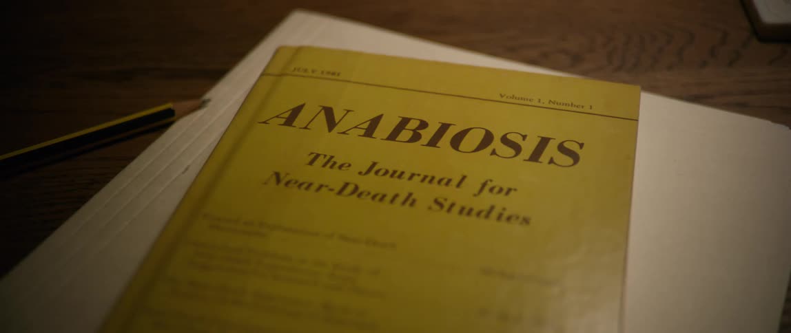 A hardcover book on a table next to a pencil