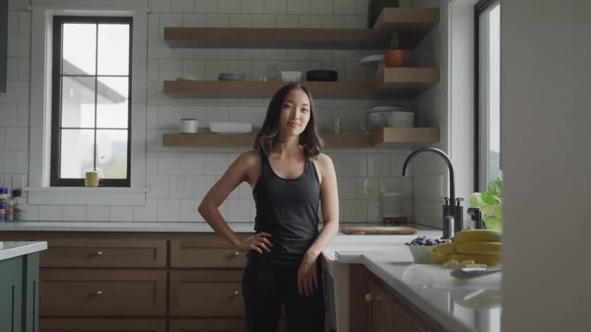 A woman smiles by the sink