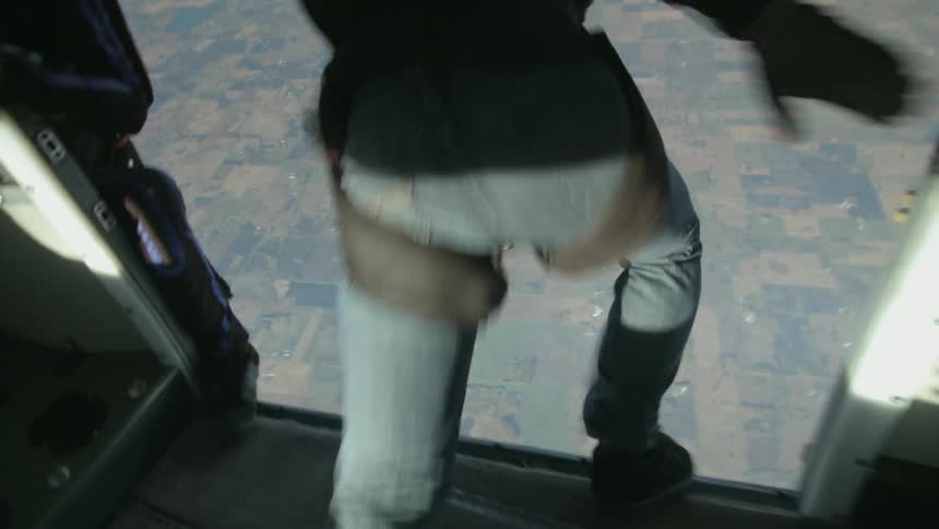 Skydivers jump from an airplane