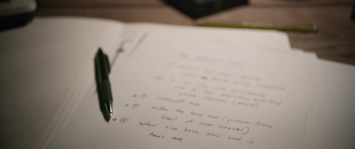 A pen and papers are on the desk