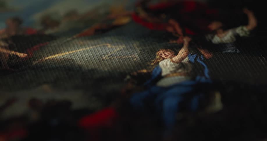 An angled closeup of a textured fabric showcases classical style painted human figures draped in tunics