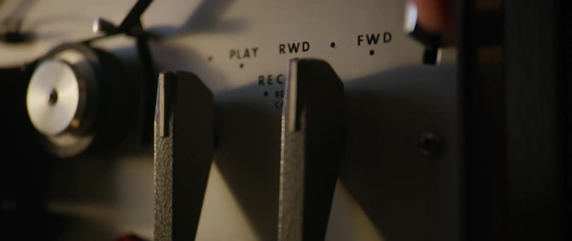 A person trying to use the forward function of a vintage tape playerrecorder