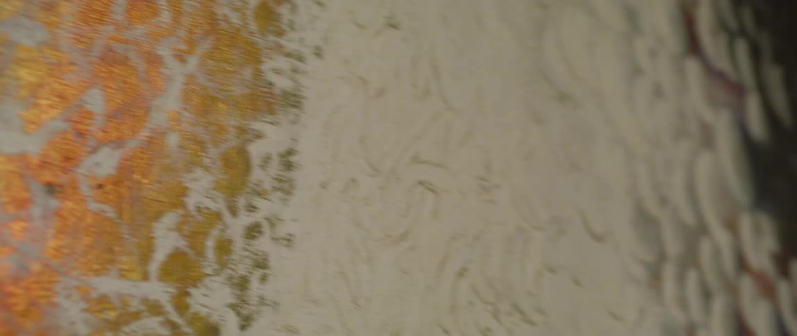 The close up of the painting shows gold and white colors