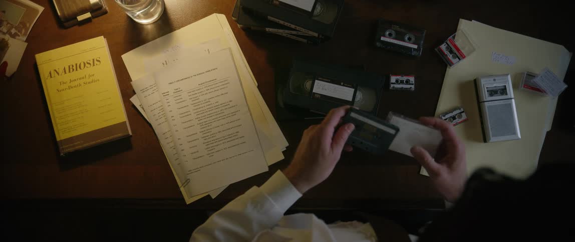 An office worker organizing evidence laid out in front of him on a desk