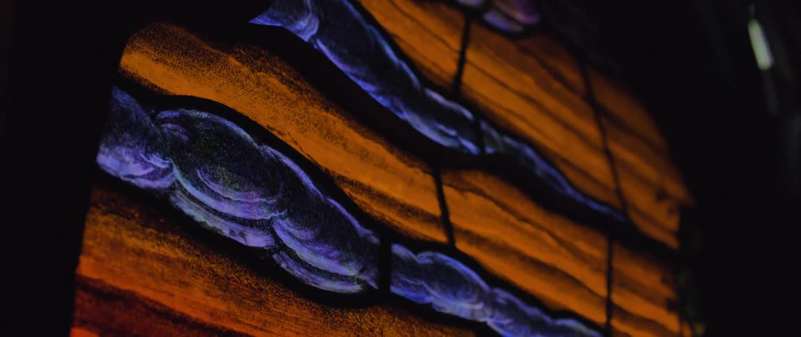 Intricate patterns of vibrant orange and blue glass form a stunning stained glass window design