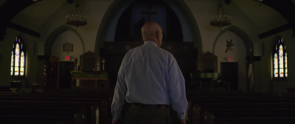 A man is walking through an empty church by himself
