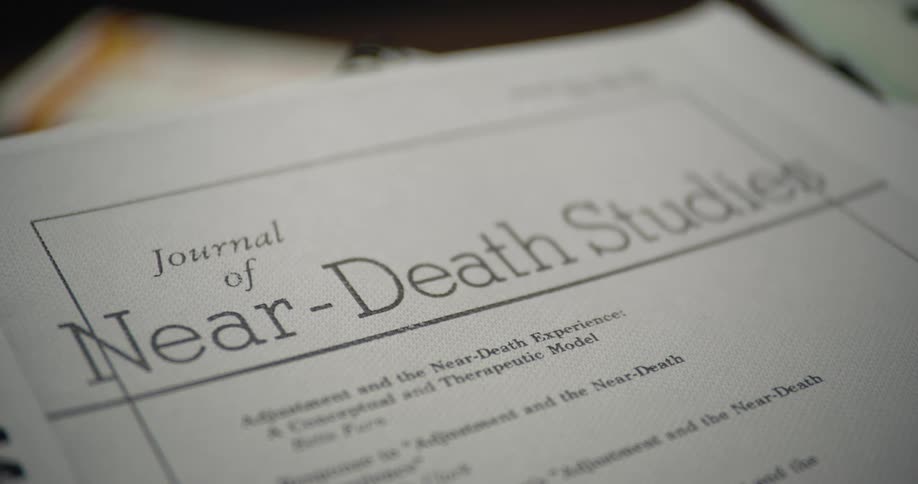 Journal of near death studies bound with a plastic binding lies on a surface