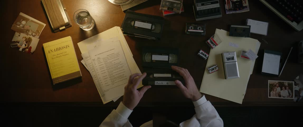 A man is looking at vhs tapes in the office