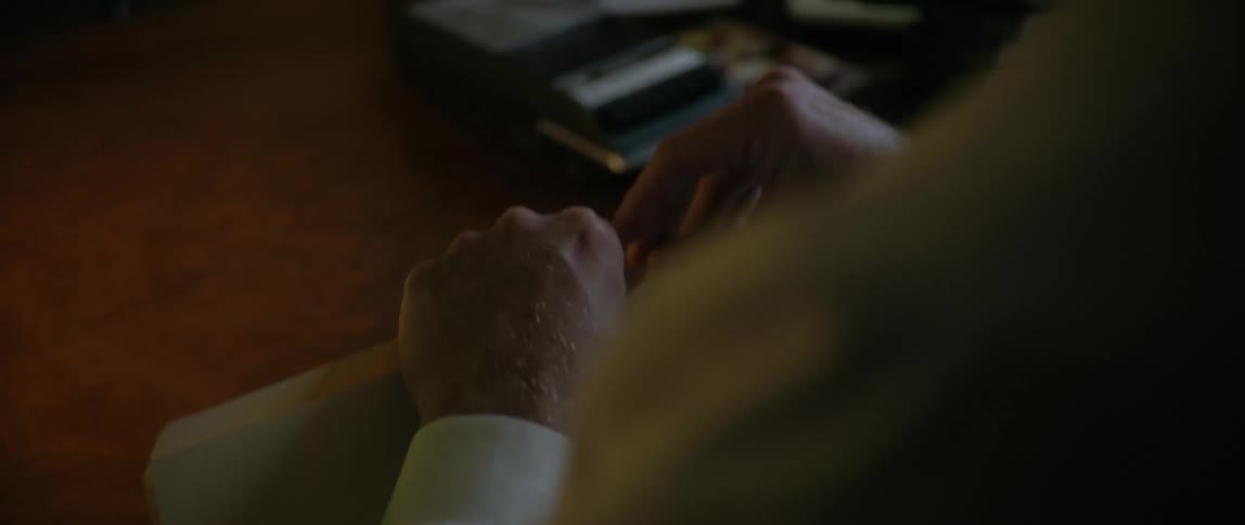 A man labels a folder and puts it on the desk