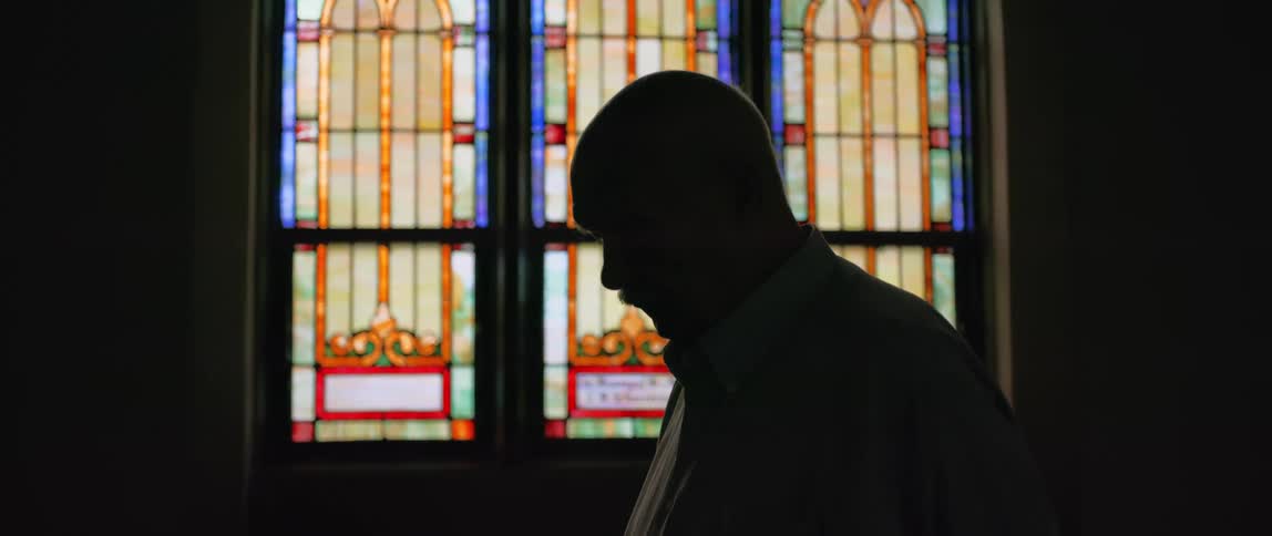 Silhouette of an elderly man inside a church