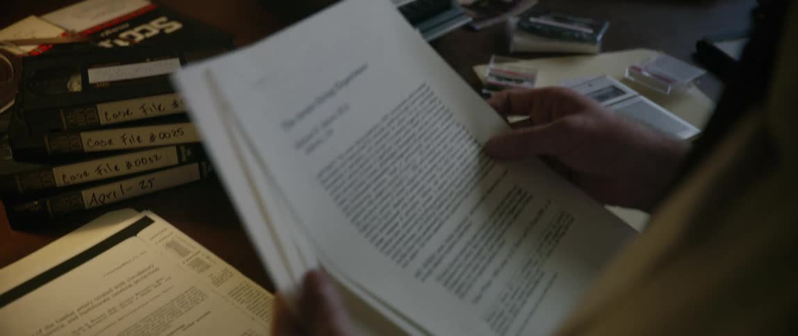 A man is reading through paperwork in the office