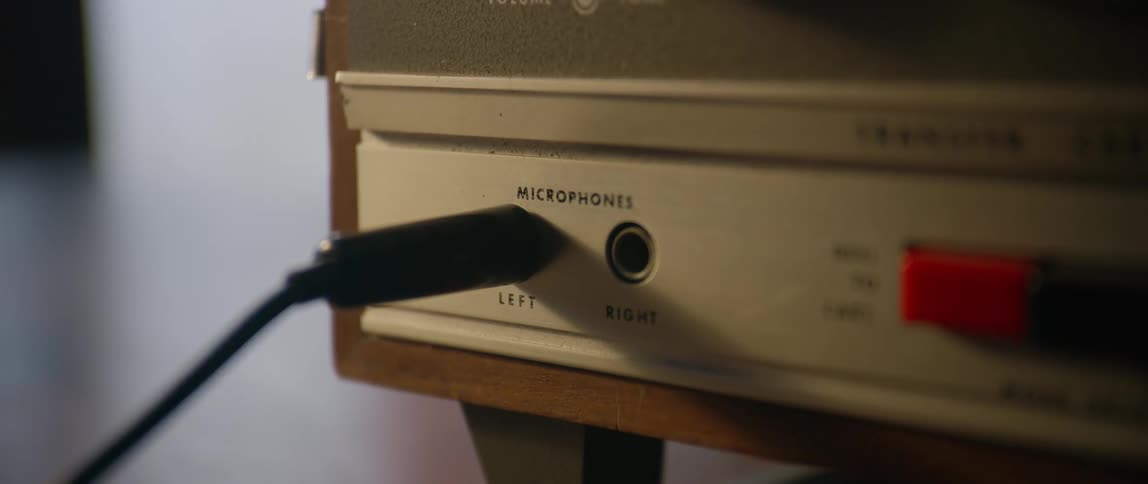 Hand putting a cable into a vintage electronic device