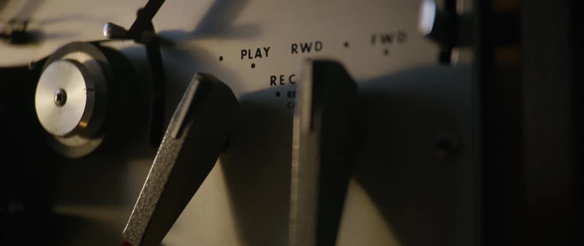 A person flips the switch on a retro film player