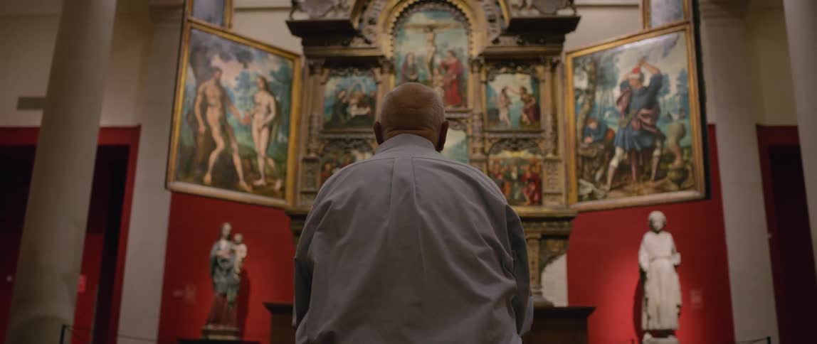 A man is viewing art in the museum