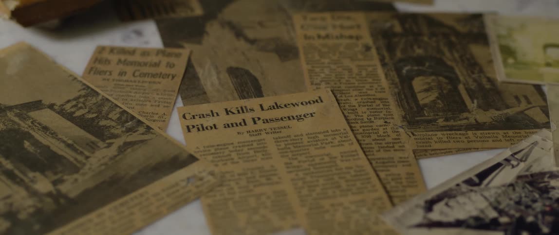 Newspaper clippings are laid out on a table