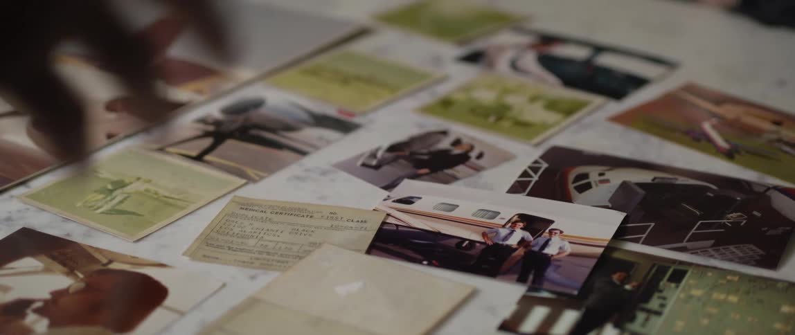A man is moving the photos around on the table