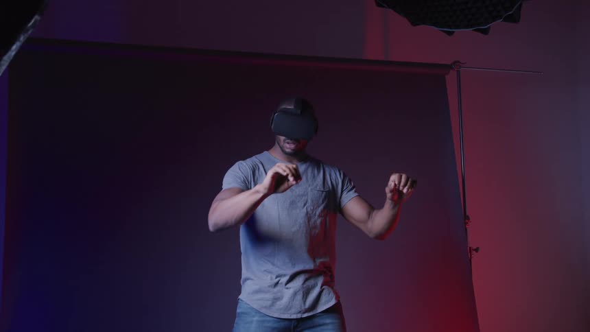 A man waves his arms around while using virtual reality