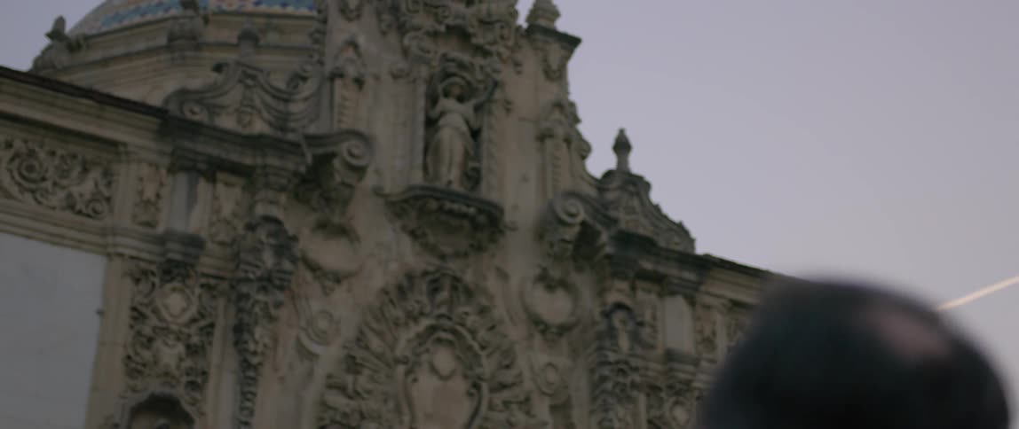 A man is looking up at an old religious building