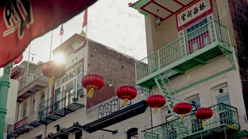 Chinese lanterns hanging on a string stretching from one house to another in a chinese neighborhood