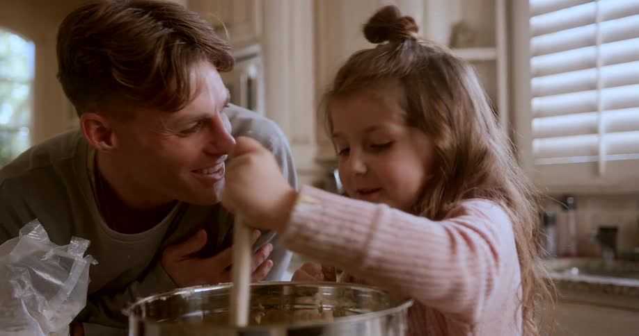 An image of a man and a little girl cooking in the kitchen