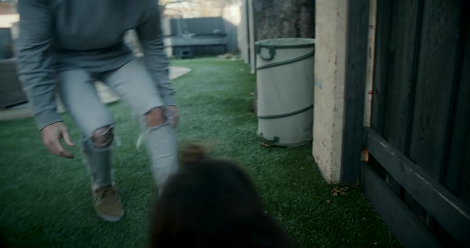 A girl is having fun on the slide in the yard while her father watches