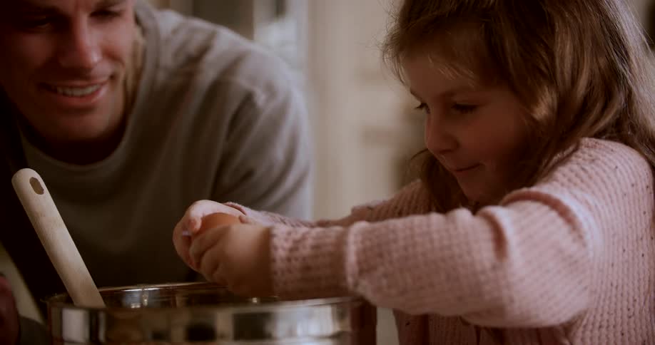 A father and his daughter are having fun cooking together